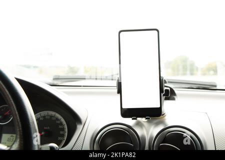 A smartphone with a poor screen on stands in the salon of a car, a windshield on a trip to Ukraine, a phone and a car Stock Photo
