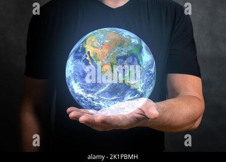 Man holds in his hand hologram of planet Earth. Earth in hands, Man holding blue Earth, Concept of communication network, internet of things and futur Stock Photo