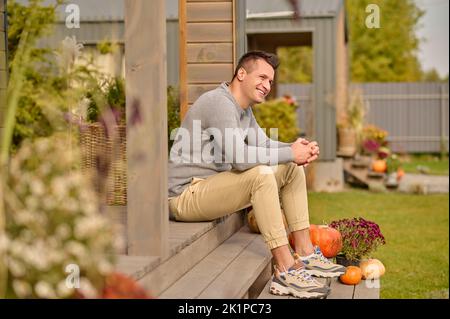 Man with a happy smile seated on the stairs outdoors Stock Photo