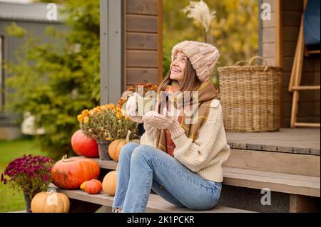 Cheerful young female enjoying her coffee break on the veranda Stock Photo