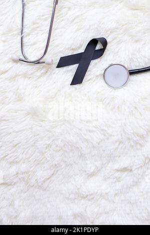 Black ribbon and stethoscope on white background. Melanoma concept ...