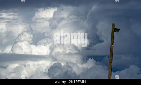 Thunderclouds filling the sky behind an old lamppost Stock Photo