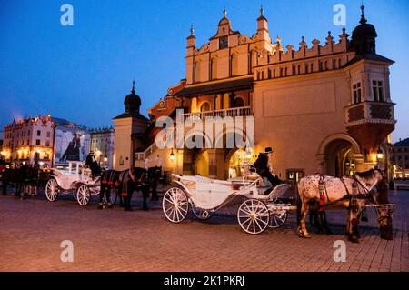 Krakow carriages in front of  Renaissance style Cloth Hall on Main Square or Rynek Glówny in Poland. Stock Photo