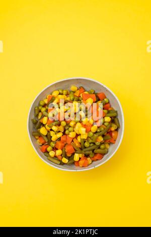 boiled fresh various vegetables in the bowl on yellow paper Stock Photo