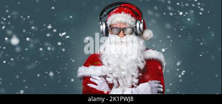 Cool Santa Claus is listening music in headphones Stock Photo