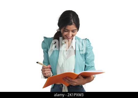 Young Venezuelan woman looking at the paperwork in a folder, isolated. Stock Photo