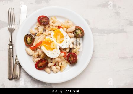 Salad with Fried cod fish and white beans on the plate. Stock Photo