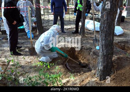 IZIUM, UKRAINE - SEPTEMBER 19, 2022 - Investigators and forensic experts exhume the bodies of Izium residents tortured to death by Russian invaders at Stock Photo