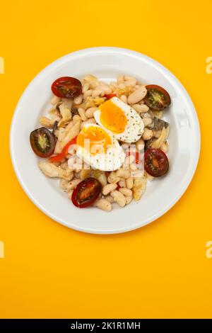 Salad with Fried cod fish and white beans on the plate. Stock Photo