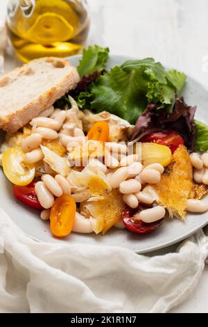 fried cod fish with white beans on the plate Stock Photo