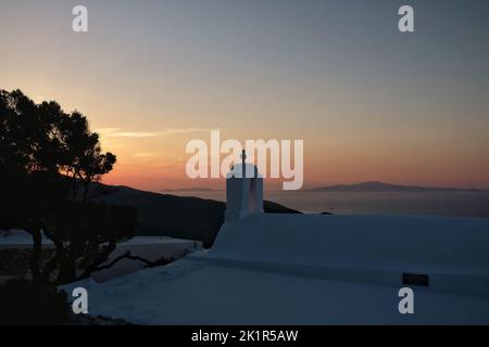 View of the beautiful and whitewashed Paleokastro Monastery at sunset and the Aegean Sea in the background Stock Photo