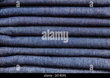 Close up stack of blue denim jeans on display in a clothes shop or store Stock Photo