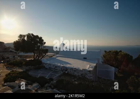 View of the beautiful and whitewashed Paleokastro Monastery at sunset and the Aegean Sea in the background Stock Photo