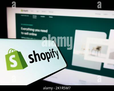 Mobile phone with logo of Canadian e-commerce company Shopify Inc. on screen in front of business website. Focus on center of phone display. Stock Photo