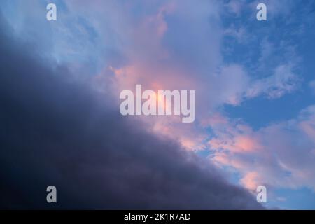 Stormy dramatic sky with clouds at sunset, divided diagonally Stock Photo