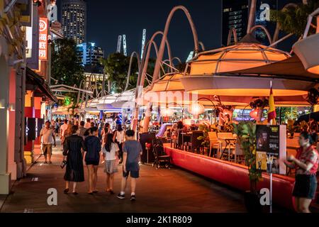 Clarke Quay on Singapore River illuminated by coloured lights with night life, restaurant.  Clarke Quay Singapore Stock Photo