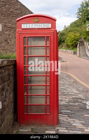 An old red public telephone box on a village street in New Lanark, Lanarkshire, Scotland, UK Stock Photo