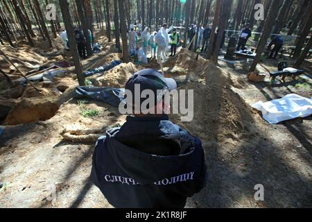 Non Exclusive: IZIUM, UKRAINE - SEPTEMBER 19, 2022 - A police investigator is pictured during the exhumation of the bodies of Izium residents tortured Stock Photo