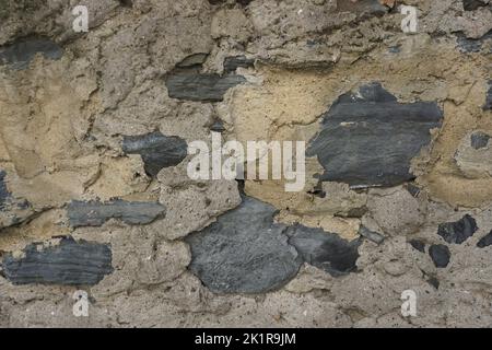 wall detail with stones visible through old plaster Stock Photo