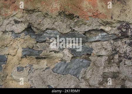 wall detail with stones visible through old plaster Stock Photo