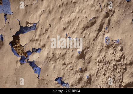 cracked plaster wall detail showing layers of blue underneath Stock Photo