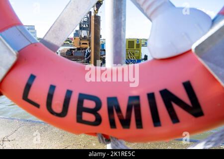 20 September 2022, Mecklenburg-Western Pomerania, Lubmin: Behind a life preserver, the construction site of the LNG terminal in the industrial port of Lubmin 'Deutsche Ostsee' can be seen, where heavy equipment is in use. The plan is to bring the cryogenic liquefied gas to the port by smaller shuttle ships from large tankers anchored outside the Greifswald Bodden. Photo: Stefan Sauer/dpa Stock Photo