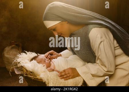 Live reenactment Christmas nativity scene of the real mother of an 8 days old baby boy playing Virgin Mary and baby Jesus Stock Photo