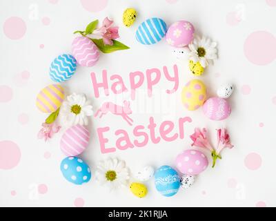 Happy Easter. Festive background. Spring holiday ornament. Pastel pink blue yellow colorful painted egg flowers round frame composition with greeting Stock Photo