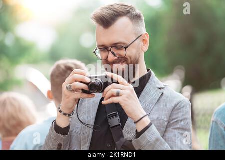 smiling male tourist looking at the screen of his camera. Stock Photo