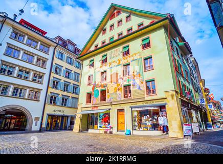 LUCERNE, SWITZERLAND - MARCH 30, 2022: Facade of old townhouse on Weinmarkt square with large wall fresco, on March 30 in Lucerne, Switzerland Stock Photo