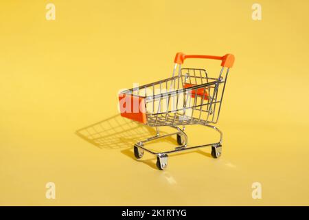 Small supermarket grocery push cart for shopping. Shopaholic. Stock Photo