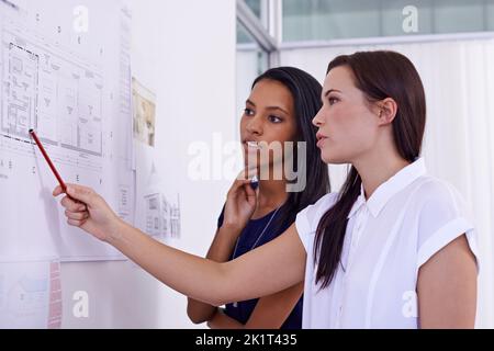 What if we changed this. two female architects examining building plans. Stock Photo