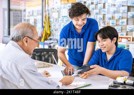 business shop male reception cashier staff care help support senior customer good service happy smile Stock Photo