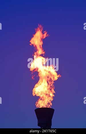 gas flare stack burning excess gases at petrochemical plant at twilight united kingdom Stock Photo