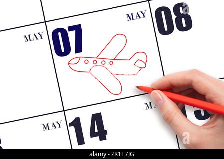 7th day of May. A hand drawing outline of airplane on calendar date 7 May. The date of flight on plane. Travel, business trips. Spring month. Day of t Stock Photo