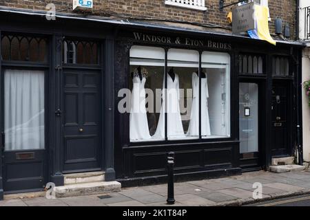 Shop window with wooden frame painted black in a Windsor shopping street selling wedding dresses. 'Windsor and Eton Brides' Stock Photo