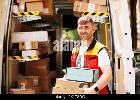 The man smiles and waits for the person to come to deliver the boxes Stock Photo