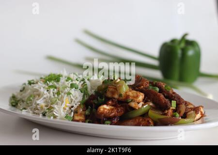 Panner Baby corn Manchurian. A crispy and crunchy Indo Chinese vegetarian dish, in a smooth gravy with stir fried capsicum and onions. Shot on white b Stock Photo