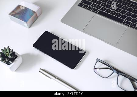 Digital business ideas. Online Business. Modern workspace with blank screen laptop, cell phone, pencil, on white work table Stock Photo