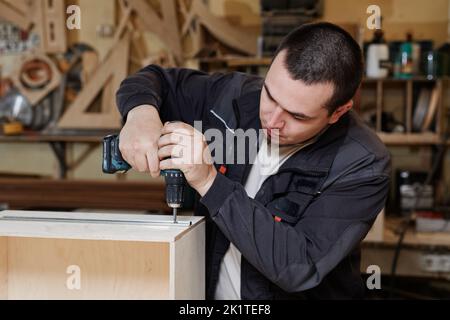 Portrait of male worker building wooden furniture in factory workshop, copy space Stock Photo