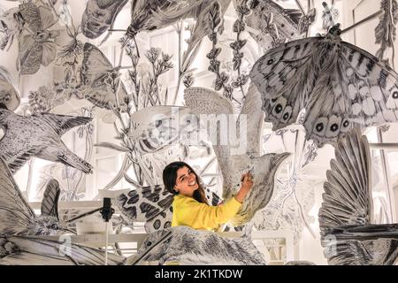 London, UK, 20th Sep 2022. The artist, Es Devlin, with her work. 'Come Home Again', large-scale illuminated sculpture by artist Es Devlin, and commissioned by Cartier, highlighting London's 243 endangered species, is lit up in the Tate Modern Garden before officially opening to the public on 22 September. The work is a 1/3 scale replica of the dome of St Paul's Cathedral filled with Devlin's drawings of the 243 species. Sunsets are accompanied by changing choirs for choral evensong. Credit: Imageplotter Stock Photo