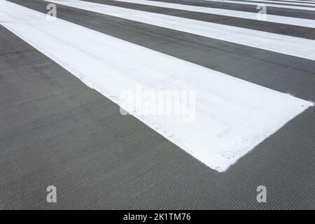 White stripes on grey asphalt, concrete marking Stock Photo