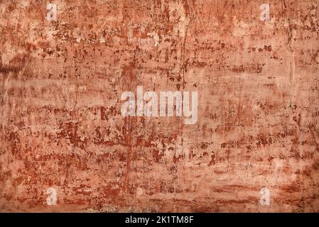 shabby red stucco with cracks and flakes of paint Stock Photo