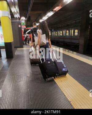 young couple in subway with suitcases, travel concept Stock Photo