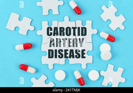 Medical concept. On a blue background, pills, capsules and puzzles with the inscription - Carotid artery disease Stock Photo