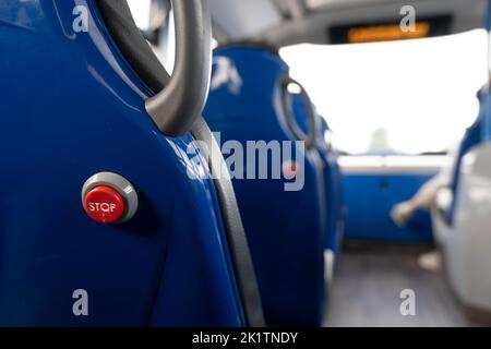 Red bus stop button to get off in the back of a seat in a double-decker bus. Cambridge, United Kingdom Stock Photo