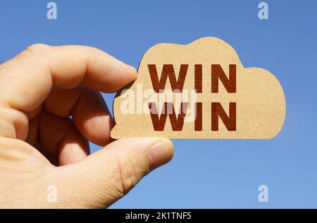 Against the background of the sky in the hands of a man, a figure of a cloud with the inscription - win win. Technology and business concept. Stock Photo