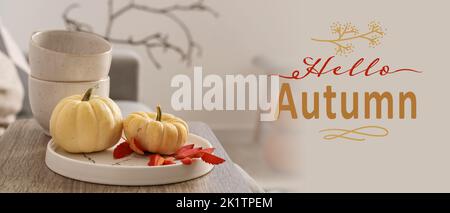 Ripe pumpkins and leaves on table in room. Hello autumn Stock Photo