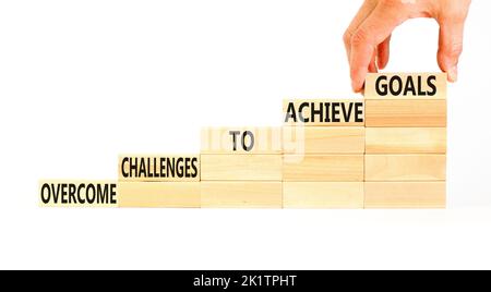 Overcome challenges to achieve goals symbol. Concept words Overcome challenges to achieve goals on wooden blocks on a beautiful white background. Busi Stock Photo