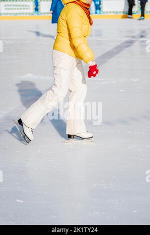 Abstract unrecognizable woman skating in park skating rink. Winter outdoor sport concept Stock Photo
